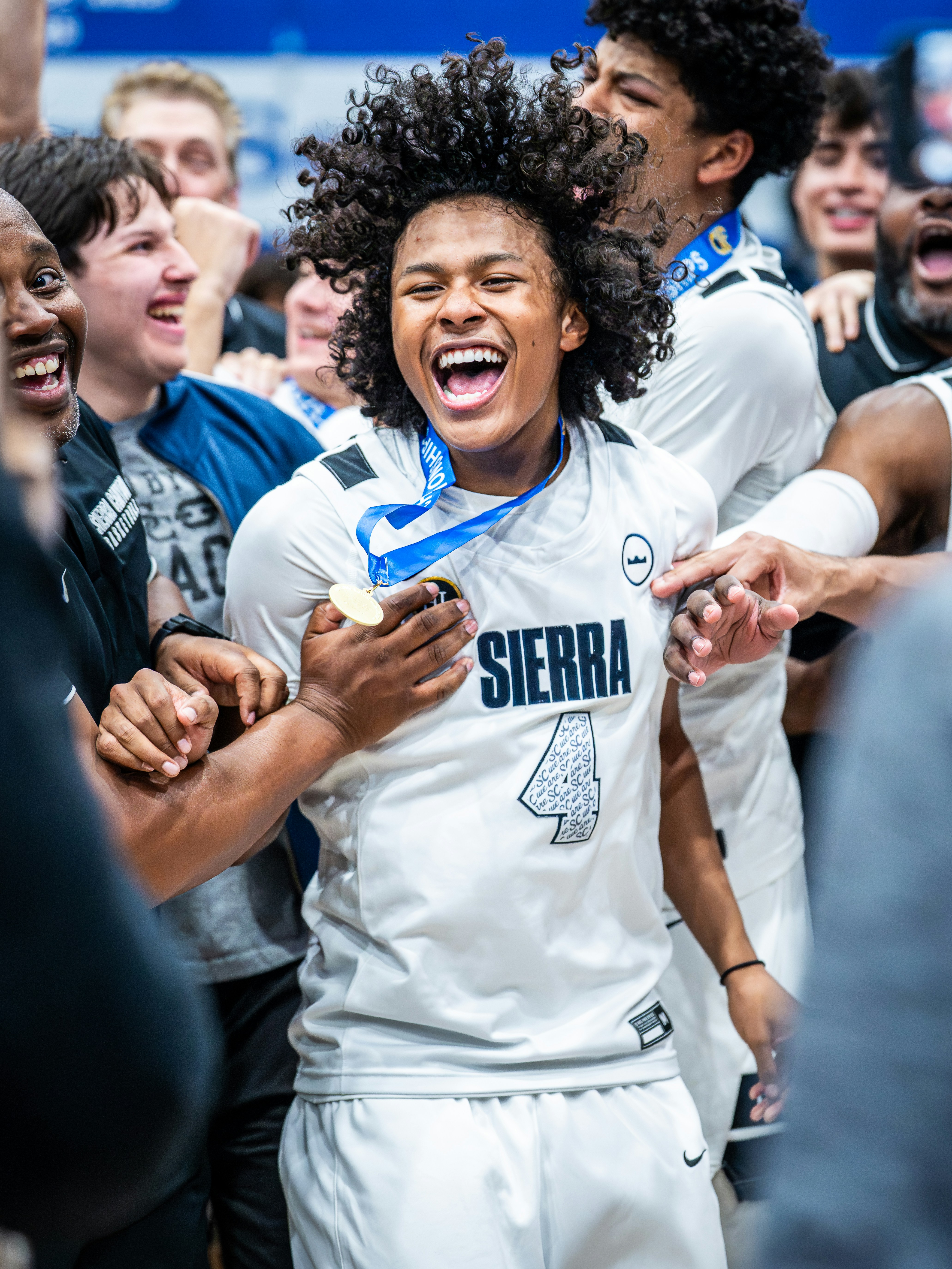 Student-athlete celebrating with teammates after a basketball championship